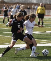 Free State defender Mckenzie Liebl, right, battles for control with Shawnee Mission East senior midfielder Andie Mitchell. SM East won, 3-0, Tuesday at FSHS.