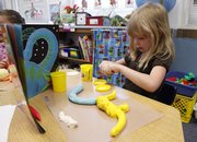 New York School kindergartner Chloe Gulotta, 6, works on a model of a dinosaur in teacher Kim Gamble’s classroom.