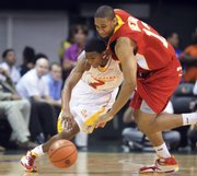 In this April 1 photo, west player Xavier Henry, right, battles for a loose ball against East player Dexter Strickland in the McDonald’s All-American Game in Coral Gables, Fla.