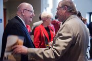 Kansas University chancellor Robert Hemenway, left, receives a handshake from Bill Myers at the goodbye event Saturday at the Lied Center celebrating the chancellor’s 14 years of leadership.