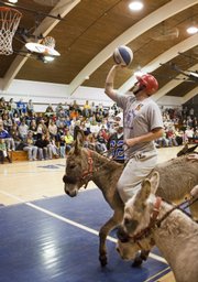 A player prepares to shoot the ball as he guides his mount toward the basket during a donkey basketball event in Moravia, Iowa, in this March 30 photo. Invented in the 1930s, donkey basketball was seen as affordable Depression-era entertainment. The “sport” morphed through the years into a popular fundraising vehicle for schools and other organizations. But animal rights groups contend the donkeys are mistreated by participants and handlers.