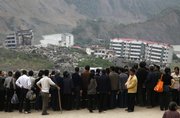 Chinese visitors gather Tuesday to look at the quake devastated town of Beichuan, in southwestern China’s Sichuan province, one year after a deadly earthquake. State leaders laid flowers and survivors burned paper money for departed spirits as a mournful China marked the first anniversary Tuesday of a devastating earthquake that left nearly 90,000 people dead or missing and 5 million homeless.