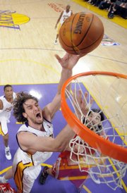 Los Angeles Lakers center Pau Gasol, left, puts up a shot in front of Houston Rockets forward Luis Scola. The Lakers won, 89-70, Sunday in Los Angeles.