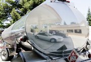 A gasoline tanker is shown at a gas station in Redwood City, Calif. Oil and gasoline prices continued to march higher Friday, having doubled in the past six months largely on optimism of a strengthening economy.