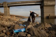 Rick Laughlin, a member of Free State Fly Fishers, walks carefully among the rocks on the face of the dam at Clinton Lake picking up trash Wednesday. Laughlin and other members of the fly fishing group and Yager’s Flies spent part of the evening cleaning up debris along the eastern side of the lake.