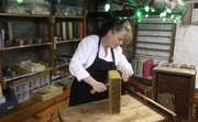 Debi Taylor, Lawrence, cuts a brick of chocolate coffee soap that she made in her rural Douglas County home. Pictured above, Taylor offers a variety of smells, including one called Shoe Bug, which helps fend off mosquitos.
