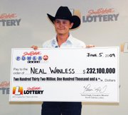Neal Wanless, 23, accepts a ceremonial check for winning a $232 million Powerball lottery jackpot Friday in Pierre, S.D. Wanless, who lives on his family’s 320-acre ranch near Mission, S.D., bought the winning ticket in the nearby town of Winner late last month.