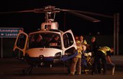 Emergency response crews move an injured person into a helicopter ambulance around 10:15 p.m. Friday at the Lecompton interchange of the Kansas Turnpike. The driver of a semi-trailer truck was injured when the rig overturned in the westbound lane of I-70 near the interchange.