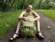 Andrew Williams poses without his shirt behind his backpack Thursday at a park near his home in Warren, Pa. Williams plans to participate Sunday in Naked Hiking Day, an annual event celebrated on the first day of summer by a relatively few enthusiasts.