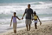 In this Aug. 12, 2008, file photo, then Democratic presidential candidate Sen. Barack Obama, D-Ill. walks down Kailua Beach in Kailua, Hawaii, with his daughters Malia, 10, left, and Sasha, 7, during their vacation in Hawaii. President Obama spoke Friday at the White House about being a father, imploring dads everywhere to be involved in the lives of their own children.