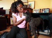 Susan Jacobs, cosmetics consultant and freelance journalist, and Kingston, her 4-year-old poodle mix, share a moment Saturday at what Jacobs describes as Kingston’s “condo within a condo” at her home in Long Beach, Calif.