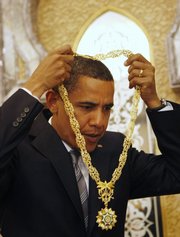 President Barack Obama takes off a gift of a gold necklace called the King Abdul Aziz Order of Merit, Saudi Arabia’s highest honor, for safekeeping after it was given to him by Saudi King Abdullah at the start of their bilateral meeting at the King’s Farm in Riyadh, Saudi Arabia, in this June 3 file photo. When U.S. presidents and diplomats meet with leaders, they often receive lavish gifts — which they can’t keep.
