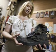Connie Ernatt holds a boot worn by Wichita Police Lt. John Galvin of the department’s Explosives Ordnance Unit in Wichita. He was injured and later died in 2000 when fireworks he was loading into a detonation pit for a training exercise ignited prematurely. Ernatt is making castings of Wichita police officers’ boots and shoes for the Law Enforcement Memorial that will be outside Wichita City Hall.