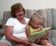 Anita Preston and her 5-year-old granddaughter Ashlyn Preston read a book at her home in Kennesaw, Ga., in this June 26 photo. Ashlyn is visiting from Florida to stay with her grandparents for the entire summer in lieu of day care or summer camp.