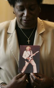 Ann Hines holds an undated photo of her husband, former soul and funk guitarist James Hines, in her home in Allendale, S.C., in this April 2 file photo. Employees of a funeral home cut the legs of Hines, a 6- foot-7 man, without the family’s permission so the corpse would fit in a casket.
