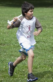 A group of young NASA space campers learned about forces of flight and challenges of space travel at the South Park Recreation Center. Eric Wheatman, 11, runs back holding a rocket stage that parachuted back to earth.