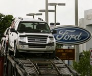 Ford vehicles are loaded onto a transporter outside a Ford dealership on Thursday in Miami Lakes, Fla. Helped by a lightened debt load, Ford Motor Co. posted a surprise second-quarter profit of $2.3 billion Thursday, following the worst loss in company history a year earlier.
