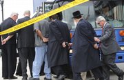 FBI agents lead arrested suspects from their headquarters Thursday as part of a corruption investigation in Newark, N.J. The mayors of three New Jersey cities, two state legislators and several rabbis were among more than 40 people arrested Thursday in a sweeping corruption investigation that began as a probe into an international money laundering ring that trafficked in goods as diverse as human organs and fake designer handbags.
