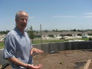 Daniel Wallach, executive director of Greensburg GreenTown, talks about the group’s “green tour” from atop the group’s first eco-home in this July 14 photo. The home is made of environmentally friendly and recycled products and includes an earth roof. The home will be used both as office space and lodging for visitors.