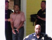 In this photo taken by a neighbor July 16, Harvard professor Henry Louis Gates Jr., center, is arrested at his home in Cambridge, Mass. Cambridge police officers attending include Sgt. James Crowley, right, and Sgt. Leon Lashley, front right.