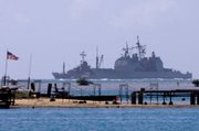 The USS Port Royal sits grounded atop a reef about a half-mile south of the Honolulu airport in this Feb. 6 photo. Hawaii plans to take the U.S. Navy to court to seek compensation for coral ruined when the Navy ship ran aground.
