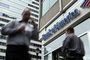 People move past a Bank of America branch in downtown Philadelphia in this May 7 file photo. Bank of America on Monday agreed to pay a $33 million penalty to settle government charges that it misled investors about Merrill Lynch’s plans to pay bonuses to its employees.