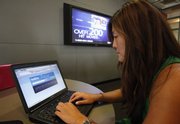 College student Joy Troy checks a Twitter page Thursday at the Annenberg School of Communication department at the University of Southern California campus in Los Angeles. A hacker attack Thursday shut down the fast-growing messaging service Twitter for hours, while Facebook experienced intermittent access problems.