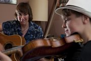 Instructor Diane Gillenwater goes over playing style with her young pupil Ethan Rhodes. The 12-year-old musician will be one of several players in the youth division at the Kansas State Fiddling and Picking Championships.