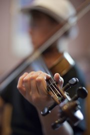 Ethan Rhodes keeps his fingers on the neck of his fiddle. Rhodes,12, will be one of several players in the youth division at the Kansas State Fiddling and Picking Championships.