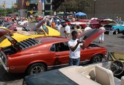 Car enthusiasts enjoy the show during the annual Dream Cruise, which spans a 16-mile stretch along Woodward Ave., Saturday in Ferndale, Mich. Automakers might be suffering, but for just a day, it looks like the glory days of car culture are back again in Michigan.