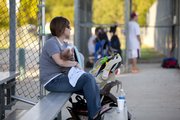 Sarah Shaffer keeps a watchful eye on husband James Shaffer’s game while feeding her newborn son, Elliott, his bottle.