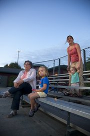 Three generations of softball supporters watch Casey Lee of Lawrence from the bleachers. From left are Casey Lee’s mother, Mary Lee, Lawrence; daughter Maya, 3; wife, Amy Lee; and daughter Cami, 1.