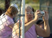 Lenette Hamm, Lawrence, composes a photo as she watches Those Sons of Pitches at the Clinton Lake Softball Complex.