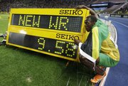 Jamaica’s Usain Bolt poses beside the indicating board after setting a new Men’s 100m World Record in the men’s final at the World Athletics Championships in Berlin on Sunday. Bolt’s feats have experts wondering whether he is approaching the limit of human speed.