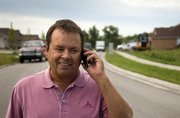 Lawrence builder Jeff Hoffman, owner of Hoffman Builders, takes a phone call while walking down Coving Drive Thursday, Aug. 20, 2009. Hoffman, who in a joint venture is building 60 units in The Cove neighborhood in west Lawrence is pleased with the slight improvements the housing market has made recently.