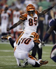 Cincinnati Bengals wide receiver Chad Ochocinco kicks an extra point Thursday in Foxborough, Mass. Holding is punter Kevin Huber.