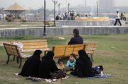 An Iraqi family picnics Friday in a park in the Azamiyah neighborhood in north Baghdad. The normally bustling streets of Baghdad are subdued, in sharp contrast to the lively atmosphere that had returned as major violence ebbed over the past two years.