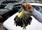 Keys to clunkers are held up by sales manager Mark Hranicky at a lot where nearly 90 cars were traded in over the past few weeks during the government’s Cash for Clunkers program in Topsham, Maine. Monday was the final day for the program.