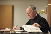 Judge Michael Malone looks over Lawrence city code in court Friday morning during a hearing with Club Axis and the city of Lawrence.