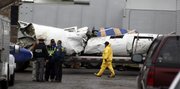 Wreckage from a plane crash is loaded onto a flatbed trailer for removal in this Feb. 18 file photo at the scene where Continental Flight 3407 crashed into a home in Clarence, N.Y. NTSB’s investigation of the crash of the flight, killing 50, has spotlighted the long hours, low pay and long-distance commutes of regional airline pilots.