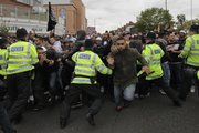 British police officers try to control anti-fascist protesters as they charge against anti-Muslim protesters in the London suburb of Harrow on Friday.