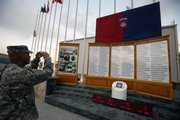 A U.S. soldier photographs names of Pentagon casualties during a ceremony to mark the anniversary of Sept. 11 at the main U.S. base in Bagram, north of Kabul, Afghanistan, on Friday. A wave of violence has spread through the country the last two days, killing more than 50 people.