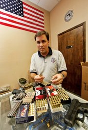 Michael Mayer explains the various types of ammunition for handguns at the Shooters’ Club on Aug. 22 in Harahan, La., a suburb of New Orleans.