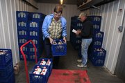 Norm Crawford, left, and Tim Iwig sort and load bottles of milk on a cart Wednesday at Iwig Family Dairy in Tecumseh before delivering the milk to Wichita. Iwig could be faced with closing his business because of record low milk prices, reduced sales because of the recession, and high feed and fuel costs.