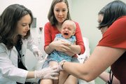 Duncan Barnes, 1, with his mother, Jennifer Barnes, gets the swine flu vaccine from Dr. Susan Henderson, left, and a seasonal flu vaccine from nurse Allison Ross, on Sept. 2 in Atlanta.