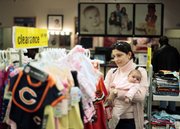 Christina Dontcheva holds her daughter Lara as she shops Wednesday at the Sears store in Chicago’s Loop. The nation’s stores saw their first sales gain in 14 months in September, a sign of life from shoppers that fuels some hope for the holiday shopping season.
