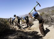 Aaron Wilson, right, of Pasadena, Calif., a recently hired worker with the California Conservation Corps, clears hiking trails with other CCC workers in the San Bernardino National Forest in Hemet, Calif., in this March 16 file photo. Eight of the 18 CCC workers were hired by the U.S. Forest Service as part of the recently approved federal stimulus plan.