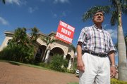 Alfonso Sanchez, pictured outside his Davie, Fla., home Thursday, cannot sell it or rent it — he can only tear the walls down and almost rebuild the house, he said. The $1.7 million home has Chinese drywall throughout the house, and Sanchez says it is now worth nothing.