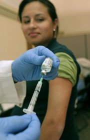 Carl Dechiara, a registered nurse, prepares the H1N1 vaccine Thursday at the Cleveland Clinic in Cleveland. The Clinic began giving H1N1 vaccine to frontline employees who provide direct patient care.