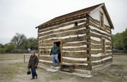 Karan and Steve Snodgrass of Fletcher, Okla., depart the Heller Cabin in Old Cowtown, in Wichita. The cabin dates to 1870 and was recently restored and moved to the entrance of Cowtown.